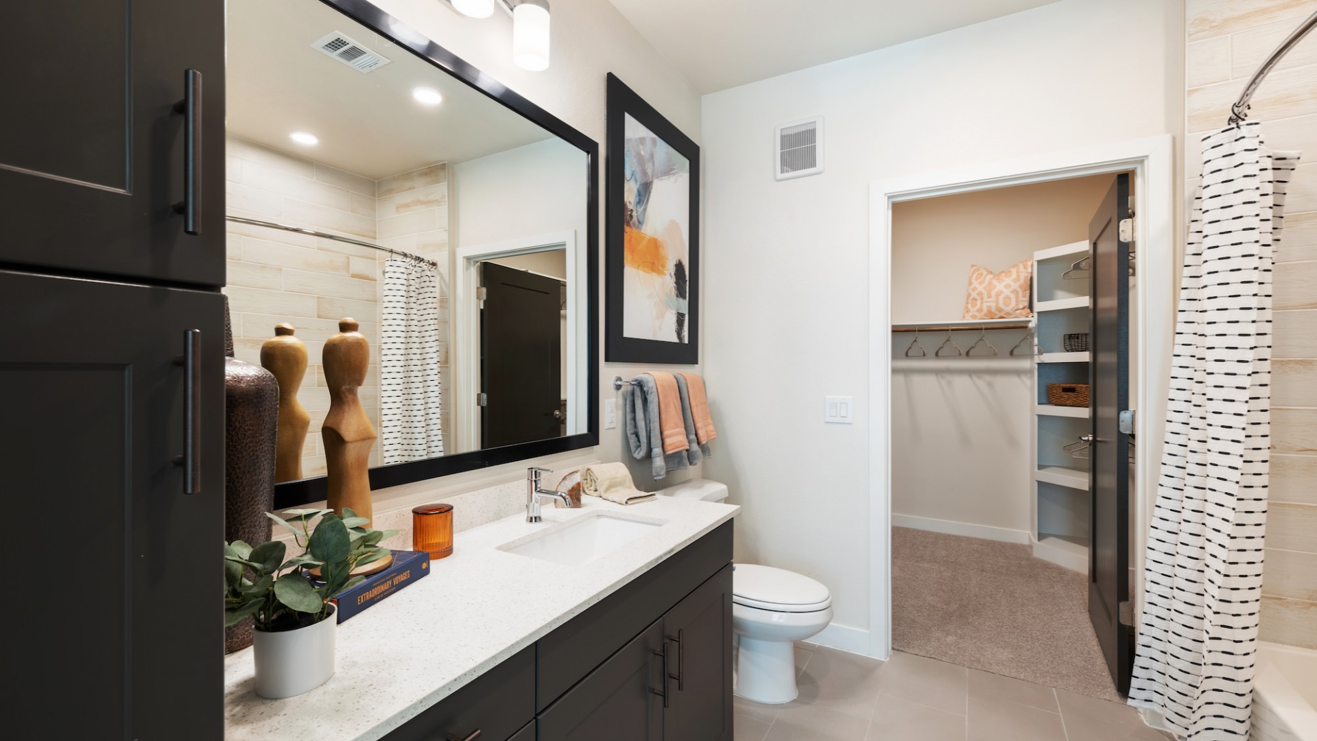 Model bathroom at our apartments in Houston, TX, featuring tiled flooring and a view of the walk in closet.
