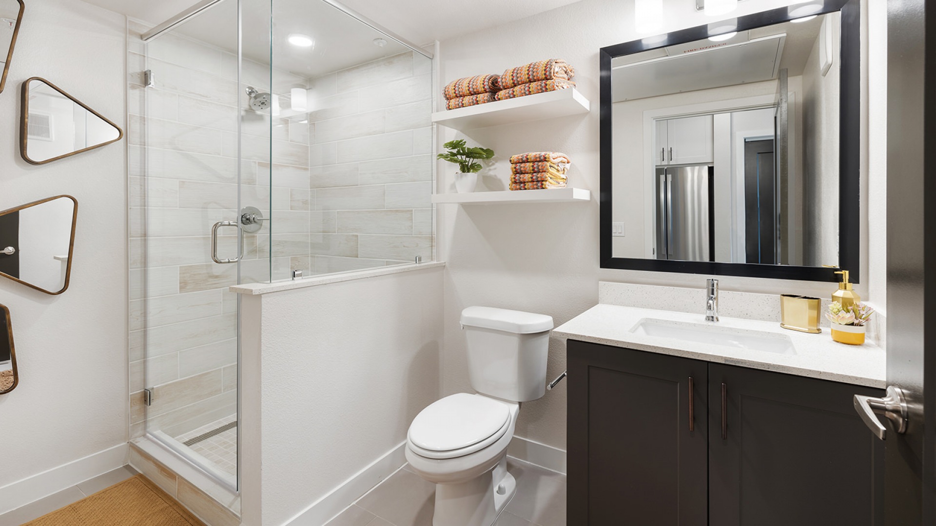 Model bathroom at our apartments in Houston, TX, featuring tiled flooring and a shower with a glass door.